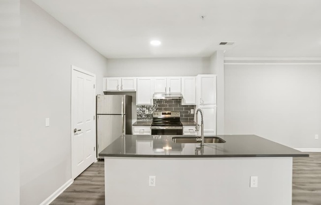 A kitchen with a black countertop and stainless steel appliances.