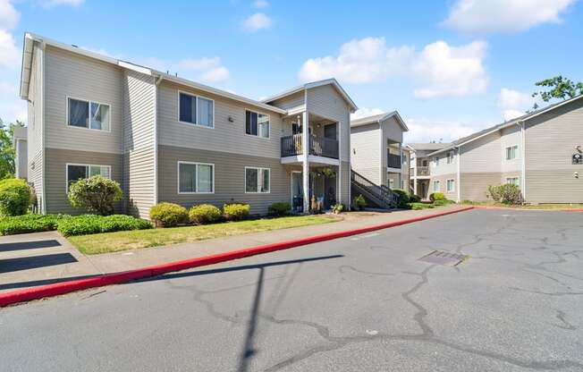 the view of two apartment buildings with a street in front of them