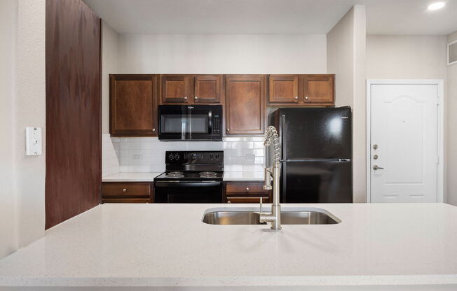 a kitchen with a white counter top and a black refrigerator at The Fairways at Star Ranch, Hutto, Texas