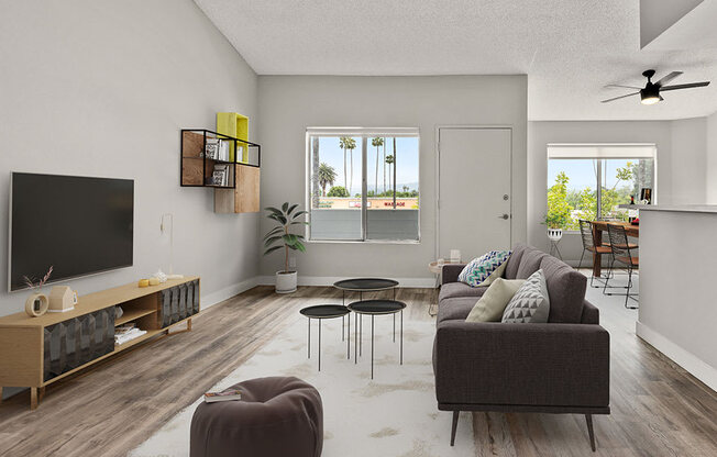 Hardwood floored living room with large windows and view of dining room.