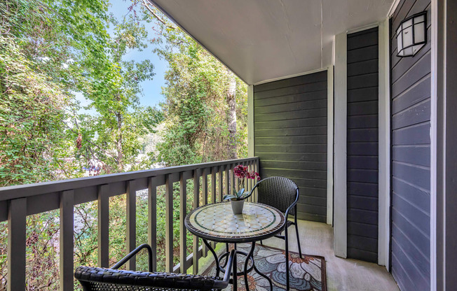 a patio with two chairs and a table on a balcony