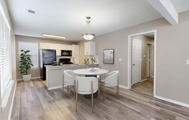 A kitchen with a dining table and chairs.