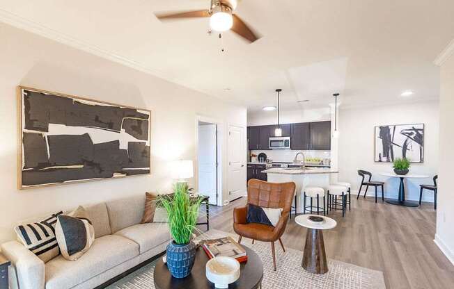 A living room with a couch, a chair, a table, and a painting on the wall.