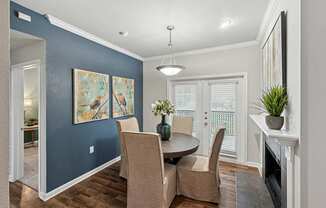 A dining room with a table and chairs.