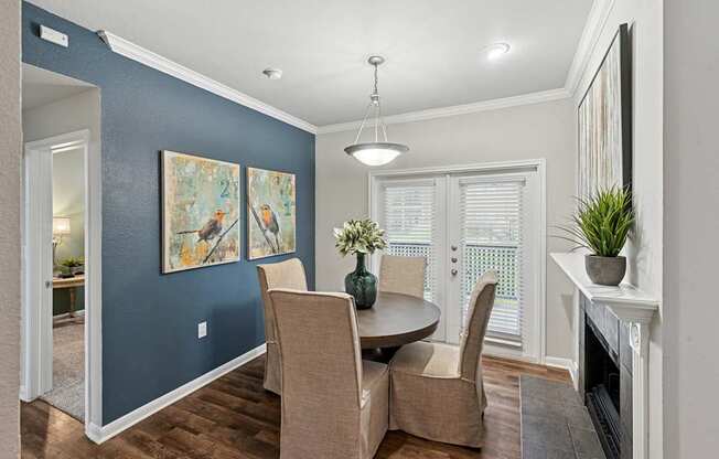 A dining room with a table and chairs.
