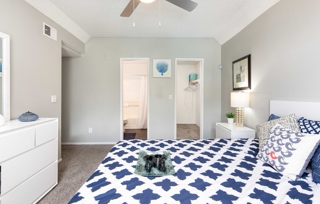 a blue and white bedroom with a bed and a ceiling fan