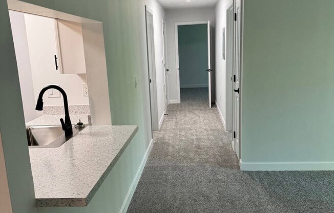 a hallway with a sink and a mirror in a house