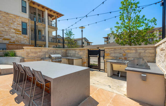 the backyard has a large table with chairs and a barbecue grill