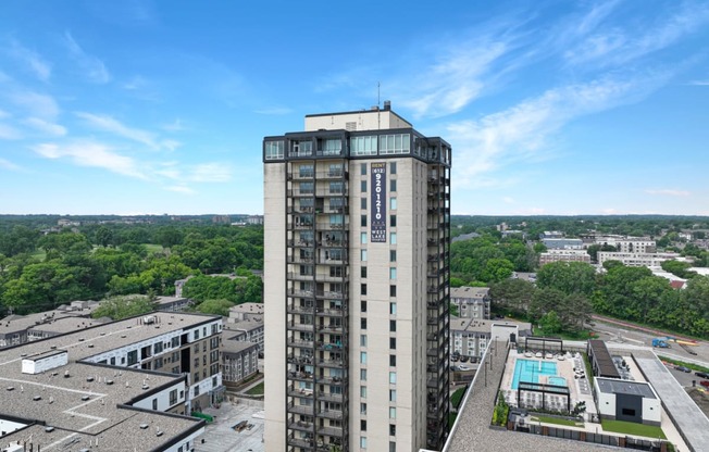 an aerial view of a tall building with a pool in front of it