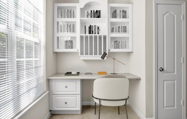 a home office with a white desk and chair and a window