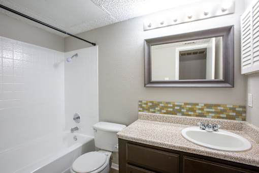 A bathroom with a toilet, sink, and a shower.
