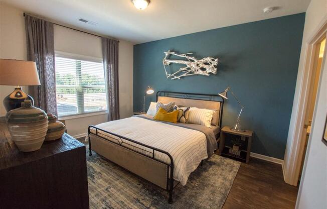 a bedroom with a bed and a blue accent wall