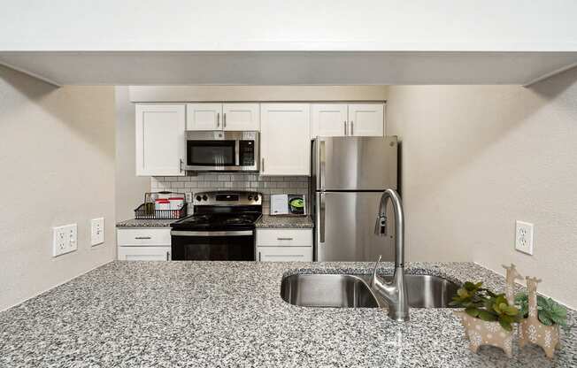 a kitchen with granite counter tops and stainless steel appliances