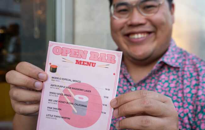 Man holding pink menu card.