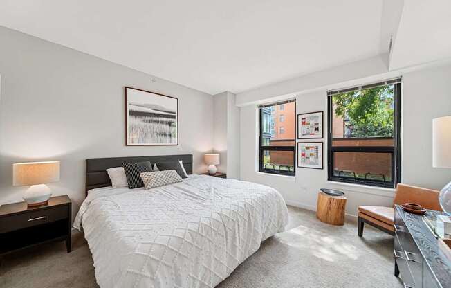 A bedroom with a large bed and a window overlooking a cityscape.