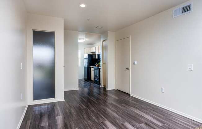 a bedroom with hardwood flooring and white walls