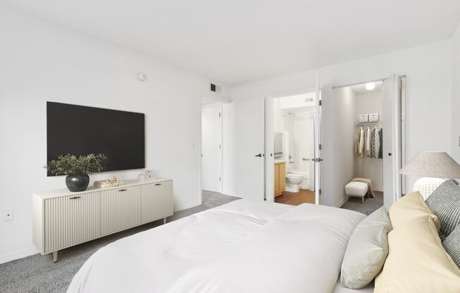 a bedroom with a large bed and a tv on the wall