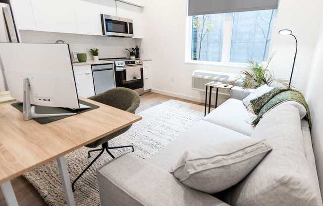 a living room with a couch and a desk with a computer