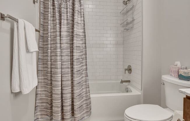 a bathroom with a white toilet next to a bathtub with a shower curtain