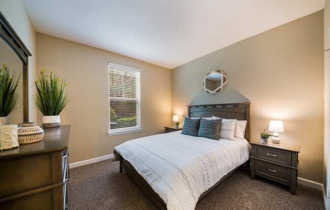 a bedroom with a bed and a dresser and a window