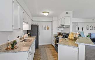 a kitchen with white cabinets and granite counter tops