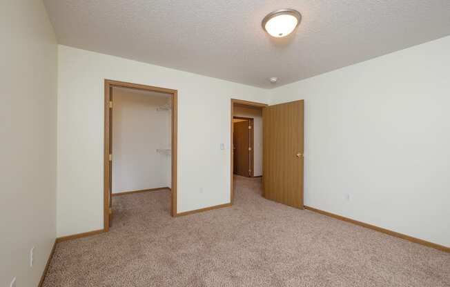 A bedroom with a walk in closet. Pinehurst Apartments | 2 Bedroom