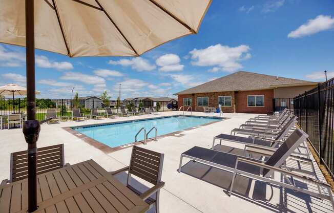 A pool area with sun loungers and a table.