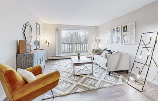 a living room with a couch and a chair and a window