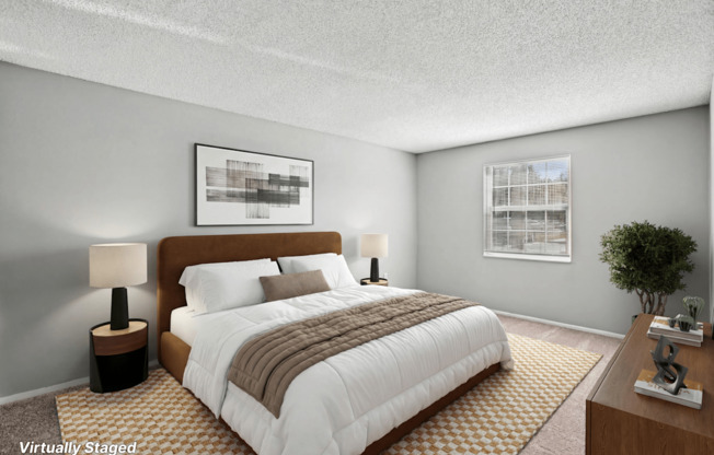 A bedroom with a large bed, a lamp, and a framed picture on the wall.