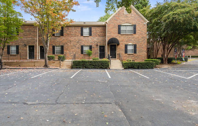 an empty parking lot in front of a brick building