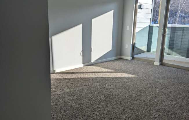 an empty living room with a ceiling fan and a window