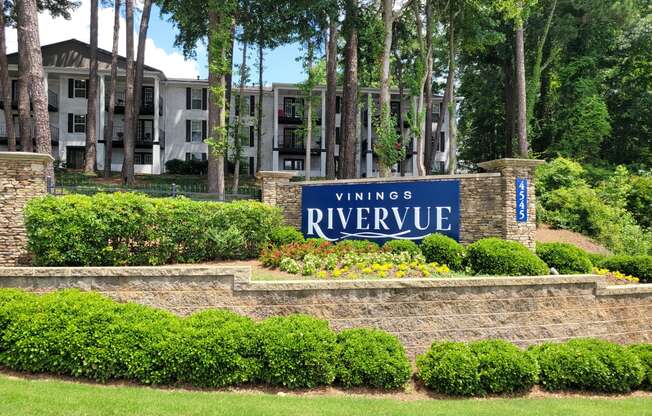 a brick retaining wall with a sign that says vinings riverplace in front of a