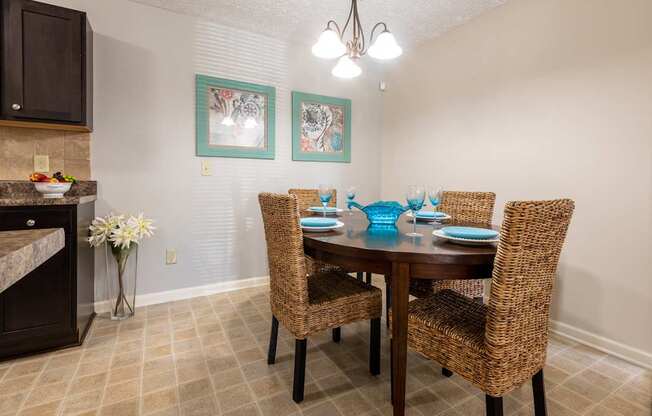 A dining room with a table set for four.