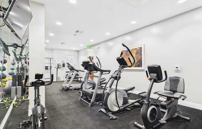 A gym with a row of stationary bikes.