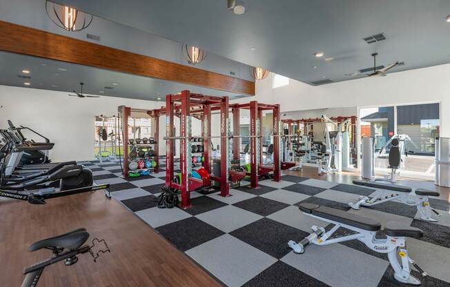 A gym with a variety of equipment including treadmills, stationary bikes, and weight machines.