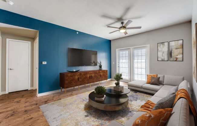 a living room with a blue accent wall and a couch and a tv