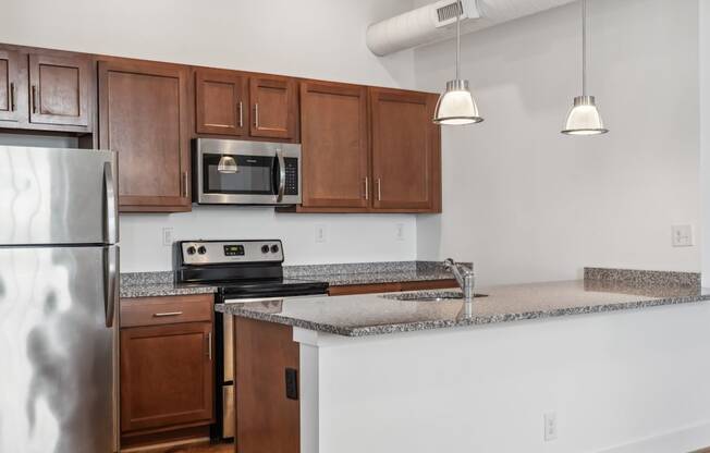 A kitchen with a stainless steel refrigerator, microwave, and oven.