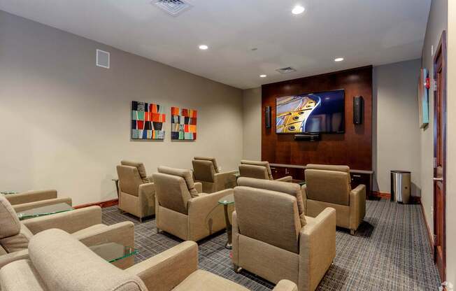 A room with a row of chairs and a television on the wall.
