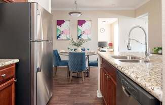 a kitchen and dining room with stainless steel appliances and granite counter tops