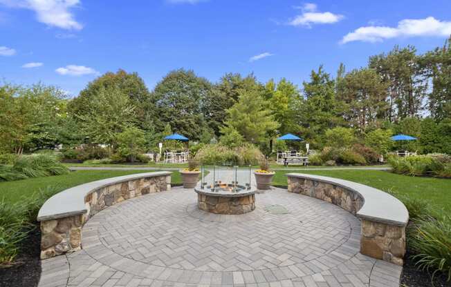 a circular stone patio with a fire pit