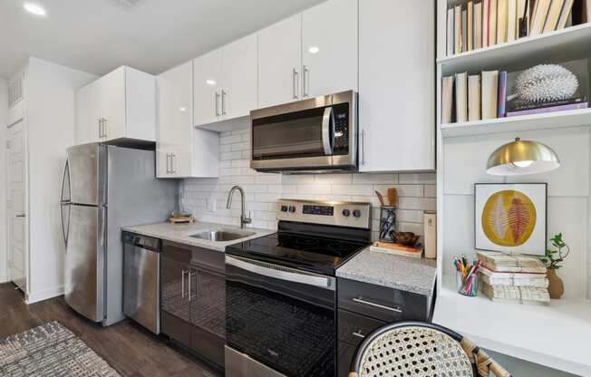 a kitchen with stainless steel appliances and white cabinets at Link Apartments® Broad Ave, Memphis, Tennessee