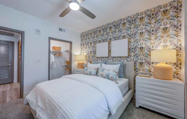 A bedroom with a large bed and a ceiling fan.