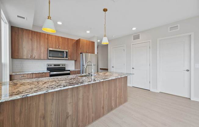 A kitchen with wooden cabinets and a marble countertop.