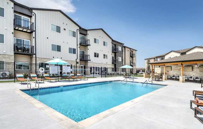 A swimming pool in front of apartment buildings.