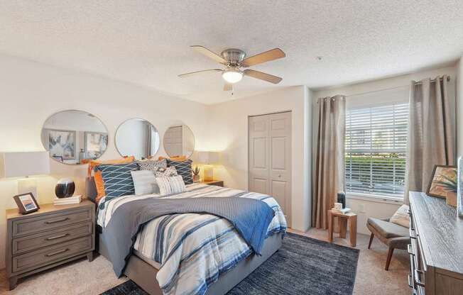 A bedroom with a large bed and a ceiling fan.