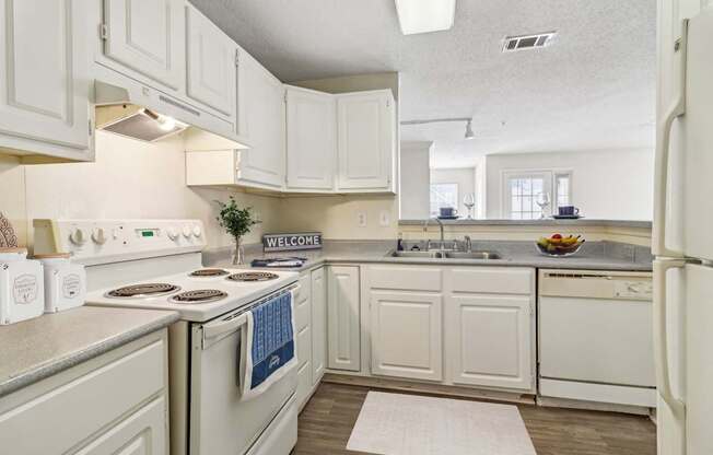 A kitchen with white cabinets and a white refrigerator.