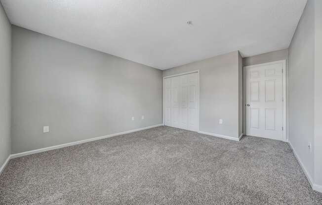 A room with grey carpet and white walls.