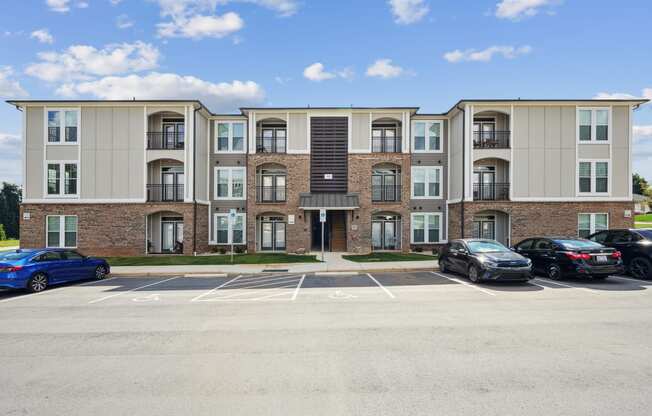 a large apartment building with cars parked in a parking lot