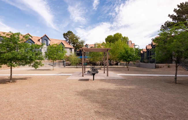 a park with a playground and trees with houses in the background