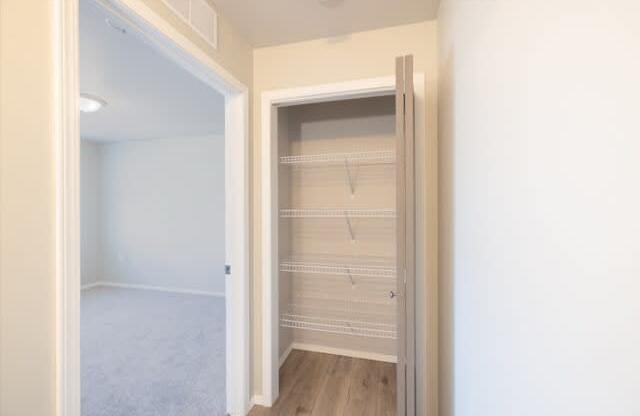 A white closet with a sliding door is open.